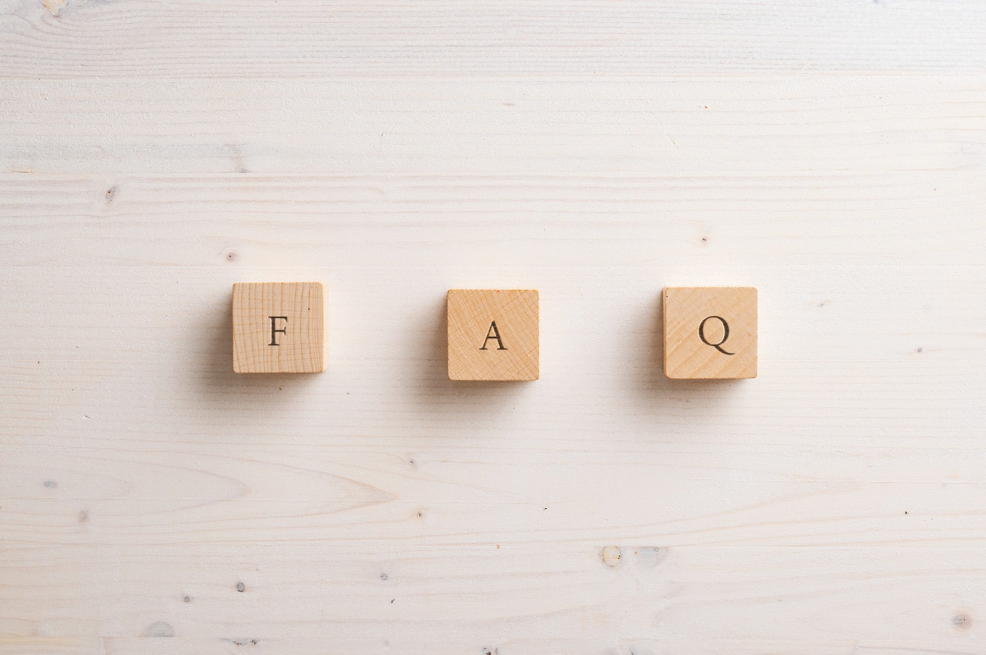 Wooden FAQ letters on light background